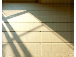 陽の光が差し込む和室の畳と麻素材の寝具。自然素材の温もりを感じさせる。